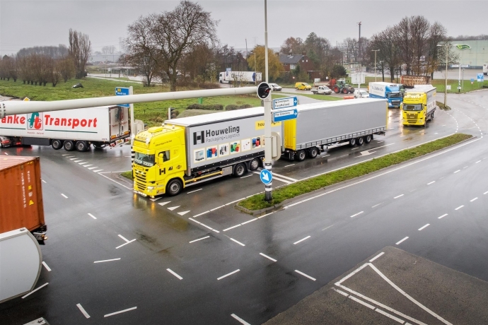 Een vrachtwagenkonvooi rijdt dicht achter elkaar en krijgen allen langer groen licht