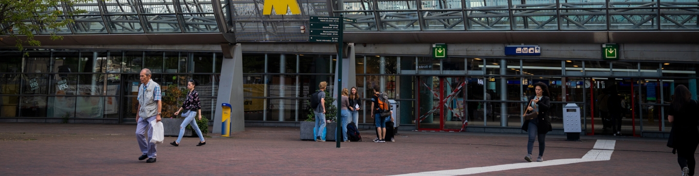Voetgangers lopen bij de ingang van station Schiedam Centrum