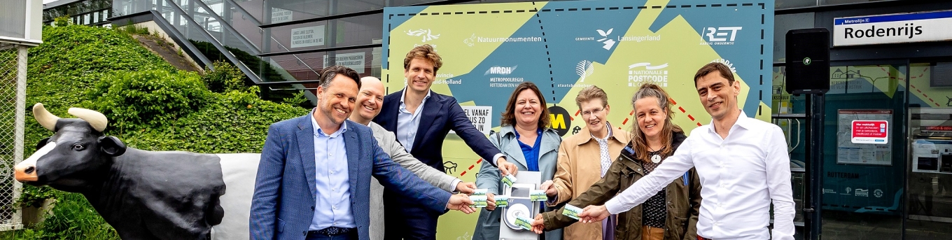 Bestuurders en directeuren openen de Groene Halte Rodenrijs. Ze staan buiten het station en checken in bij een OV-chipkaartlezer.