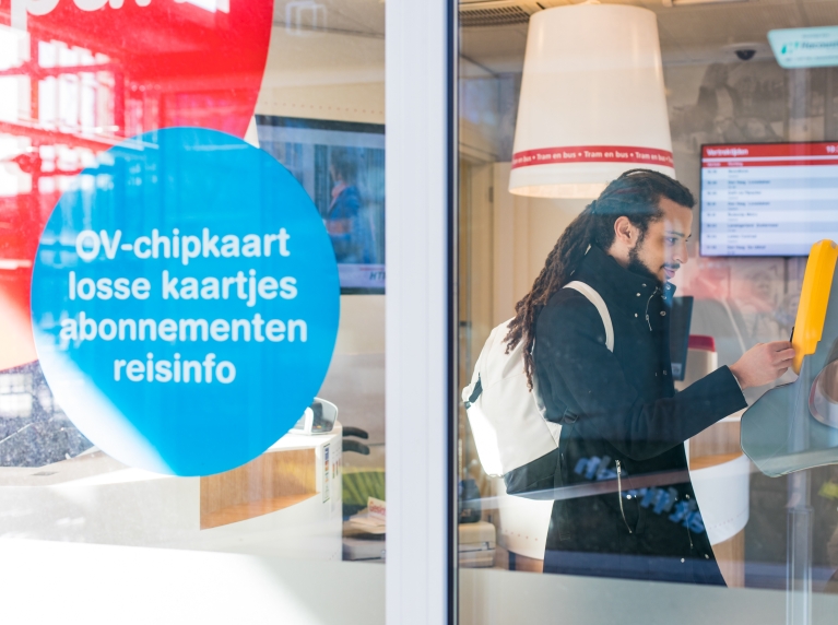 Man checkt in bij automaat ov-chipkaart
