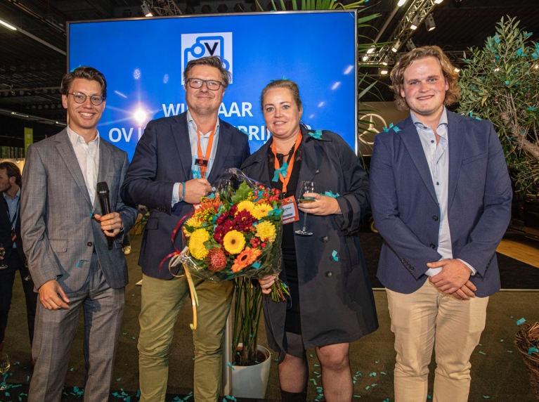 Redacteuren Sander van Vliet en Olivier Smits overhandigen de OV Innovatie Prijs '22 aan Peter Smit en Daphne Blaauw van InnOVatietram (in het midden).